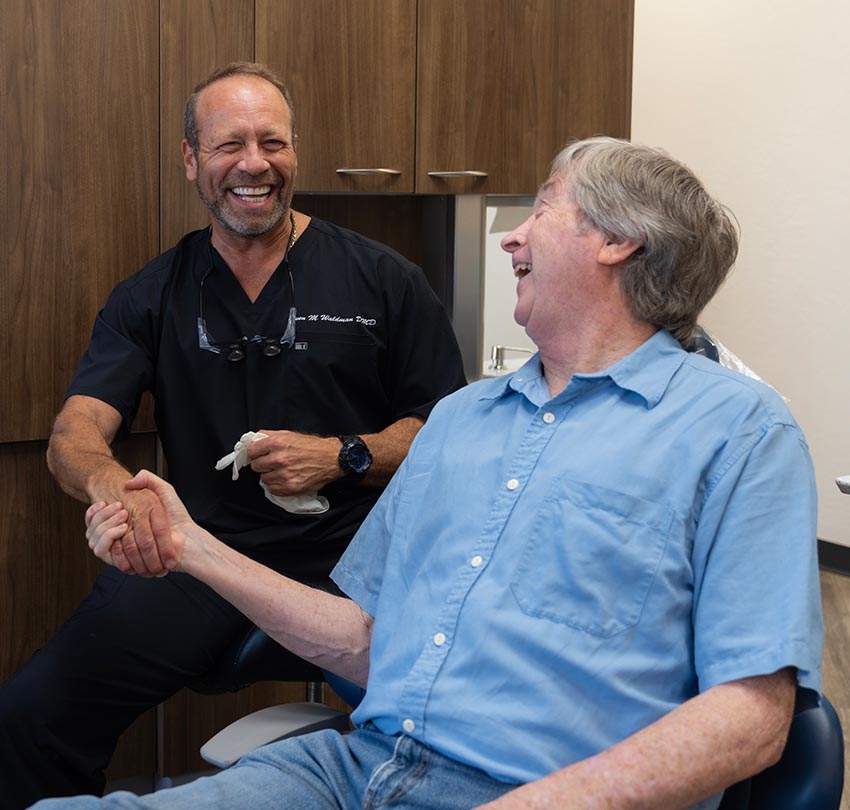Dr. Owen M. Waldman shakes hand with a seated older male patient
