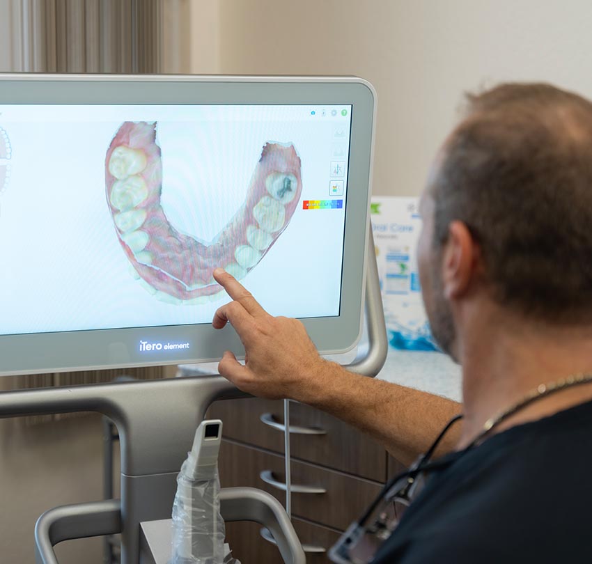 Dr. Owen M. Waldman points to a spot in a dental image in the computer monitor