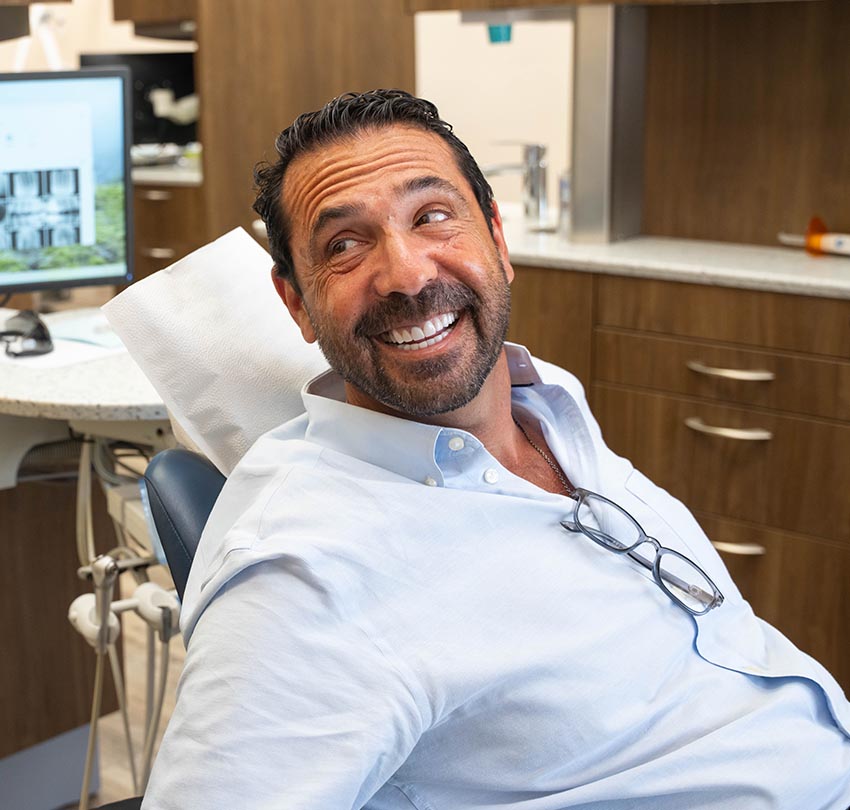 a seated male patient inside the clinic of Waldman Dental Group