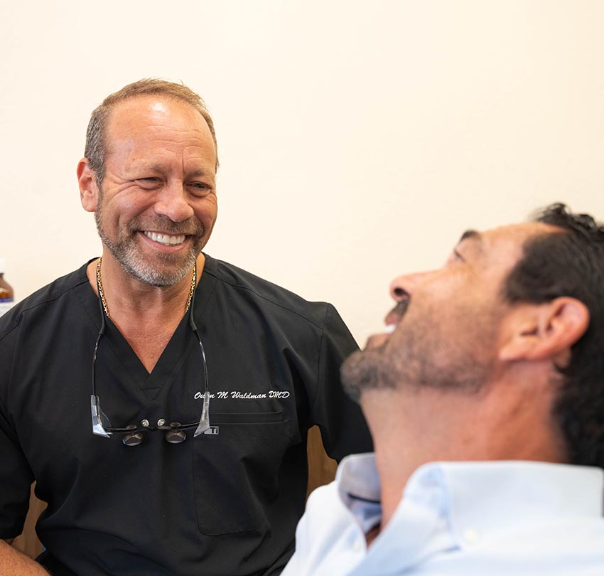 Dr. Owen M. Waldman, DMD smiles to his male patient